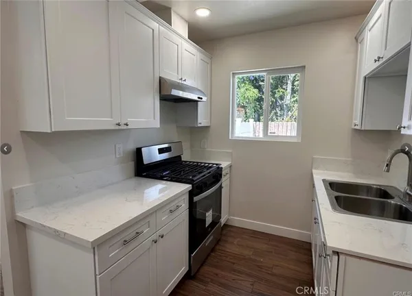 a kitchen with a sink cabinets and a window