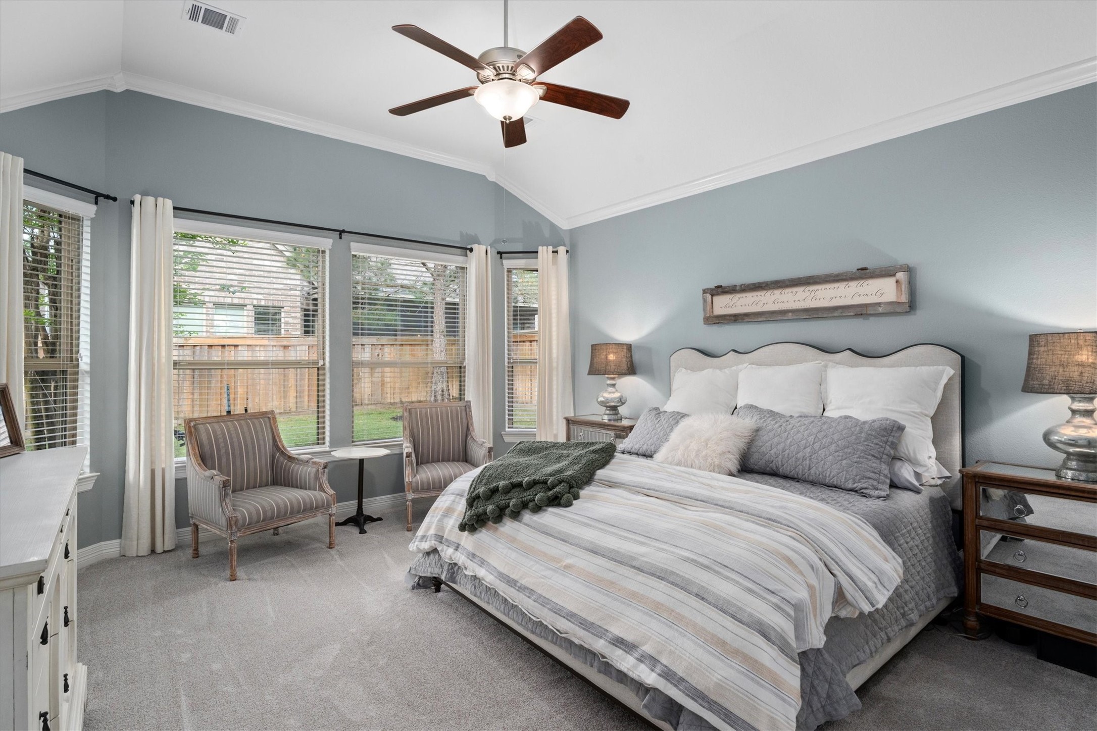 27121 Holtwood Grove Road Magnolia, TX 77354 - Photo 26 of 50 The spacious primary suite is a true retreat, featuring large windows that overlook the lush, green backyard, filling the room with natural light. With ample space for a cozy sitting area, this luxurious bedroom combines comfort and elegance, offering a private haven to unwind.