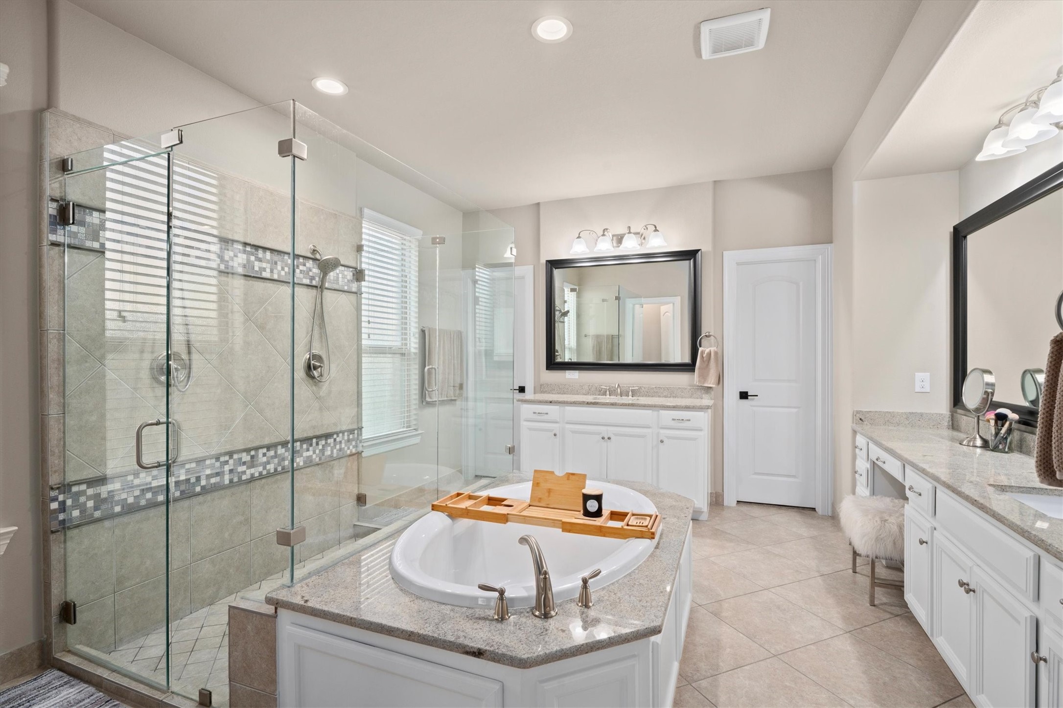 27121 Holtwood Grove Road Magnolia, TX 77354 - Photo 29 of 50 The spacious primary bathroom is designed for relaxation and convenience, featuring a luxurious soaking tub and a double-entry, walk-in shower. Dual vanities provide plenty of personal space, while the expansive walk-in closet is sure to impress with its ample storage. A thoughtfully designed retreat within your home.