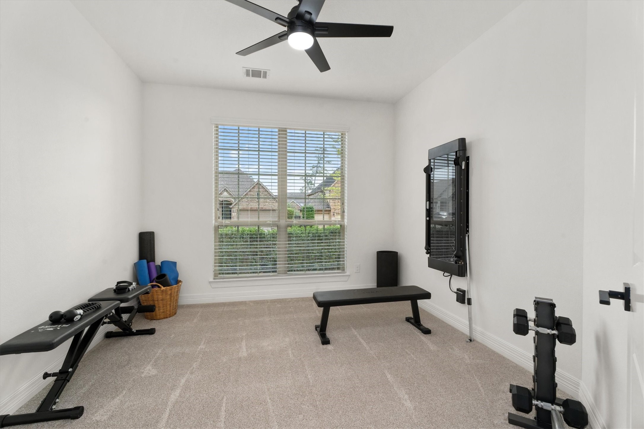 27121 Holtwood Grove Road Magnolia, TX 77354 - Photo 8 of 50 Located just across from the office, this spacious secondary bedroom is currently being used as a workout room. With endless possibilities, this space can easily transform into a guest room, playroom, or whatever suits your needs!