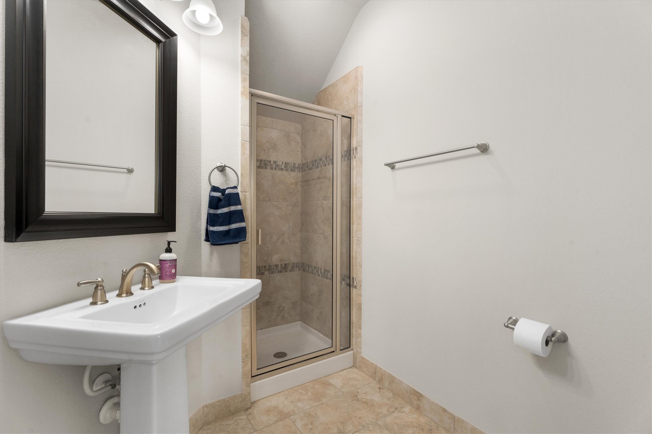 27121 Holtwood Grove Road Magnolia, TX 77354 - Photo 9 of 50 This full bathroom, conveniently located across from the downstairs secondary bedroom, features a modern stand-up shower, offering both style and functionality. It’s the perfect retreat for guests or family members, with easy access to the main living areas.