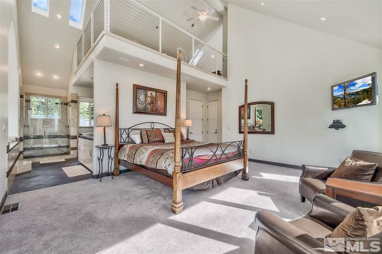 230 Chimney Rock Road Stateline, NV 89449 - Photo 11 of 25 a spacious bedroom with a bed a couch and a potted plant on the table