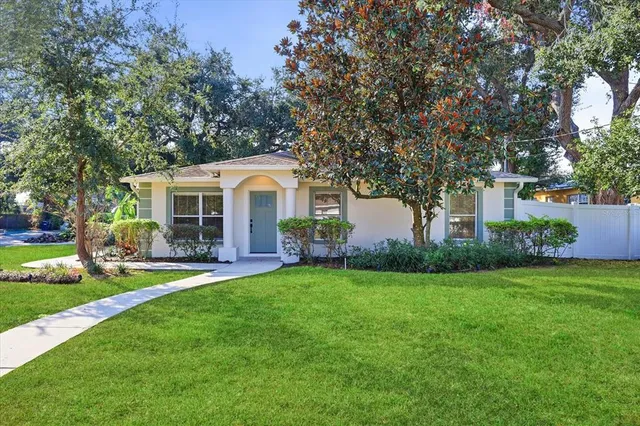 a front view of a house with a garden and yard