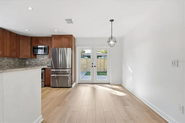 a kitchen with stainless steel appliances granite countertop a refrigerator a stove a sink and a oven with wooden floors