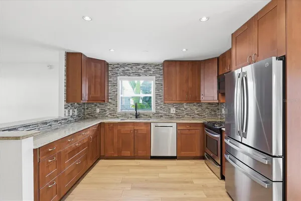 a kitchen with stainless steel appliances granite countertop a refrigerator sink and cabinets
