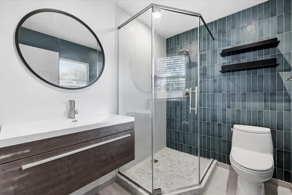 a bathroom with a sink a toilet and a mirror