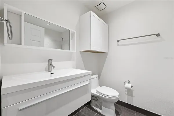 a bathroom with a sink a toilet and a mirror