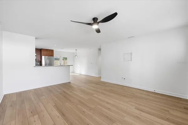 a view of empty room with wooden floor and windows