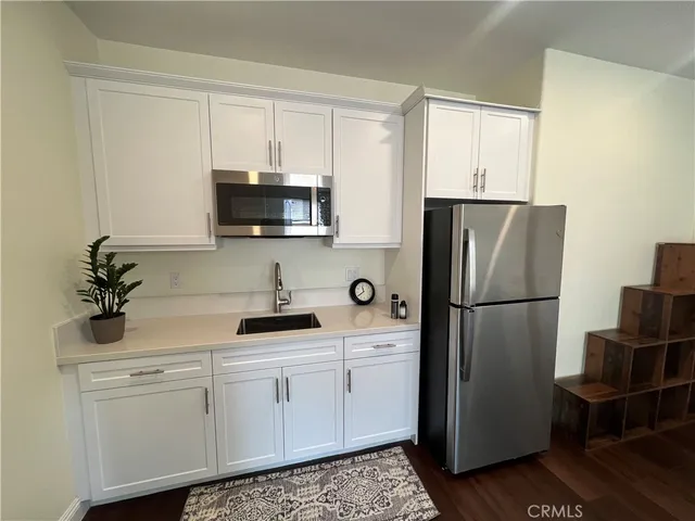 a kitchen with a refrigerator sink and cabinets