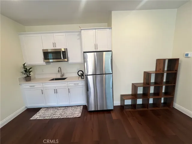 a kitchen with a refrigerator and a stove top oven