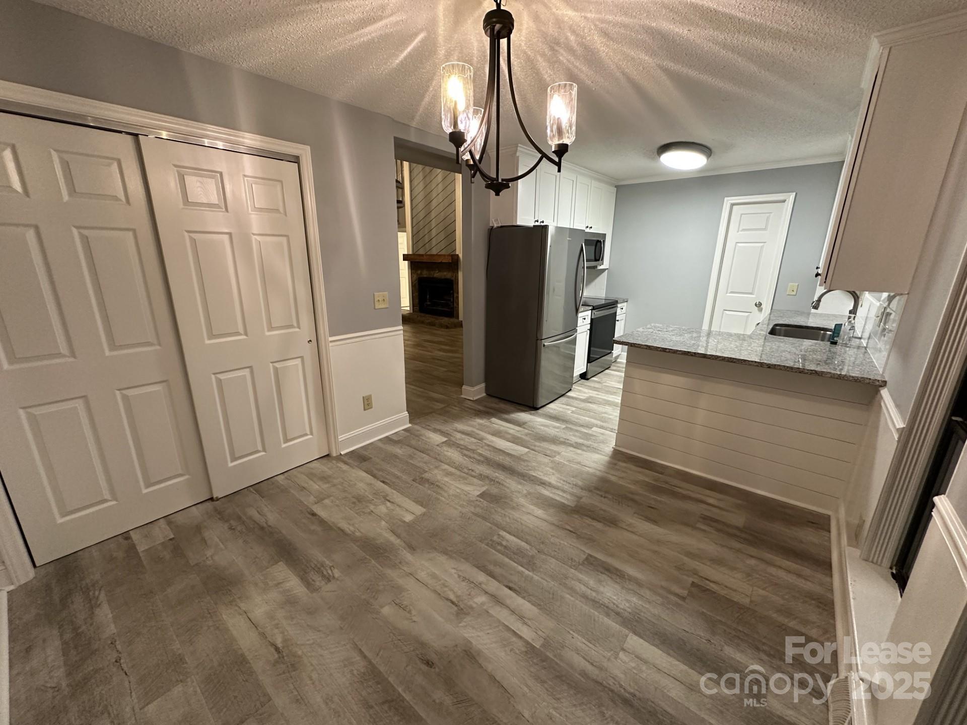 11112 5 Cedars Road Charlotte, NC 28226 - Photo 5 of 25 a view of a kitchen with refrigerator and wooden floor