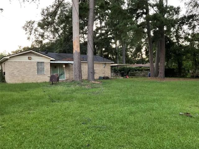 a view of a house with a yard and sitting area