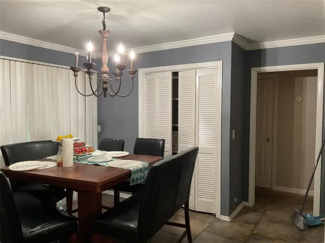 a view of a dining room with furniture a chandelier and wooden floor