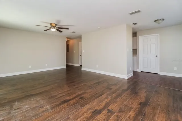 a view of a room with wooden floor and ceiling fan