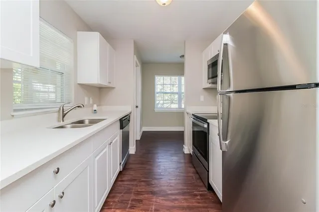 a kitchen with a sink a refrigerator and a stove