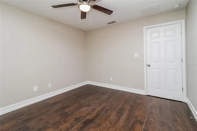 a view of an empty room with wooden floor