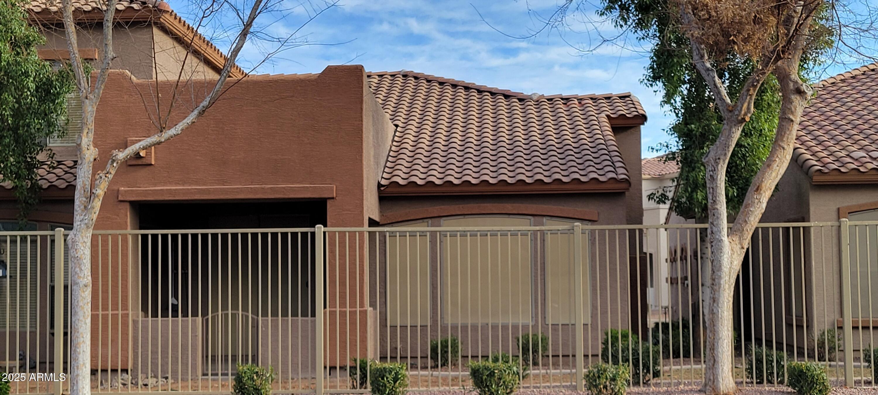 2600 East Springfield Place, Unit 108 Chandler, AZ 85286 - Photo 13 of 13 a view of a brick house with wooden fence