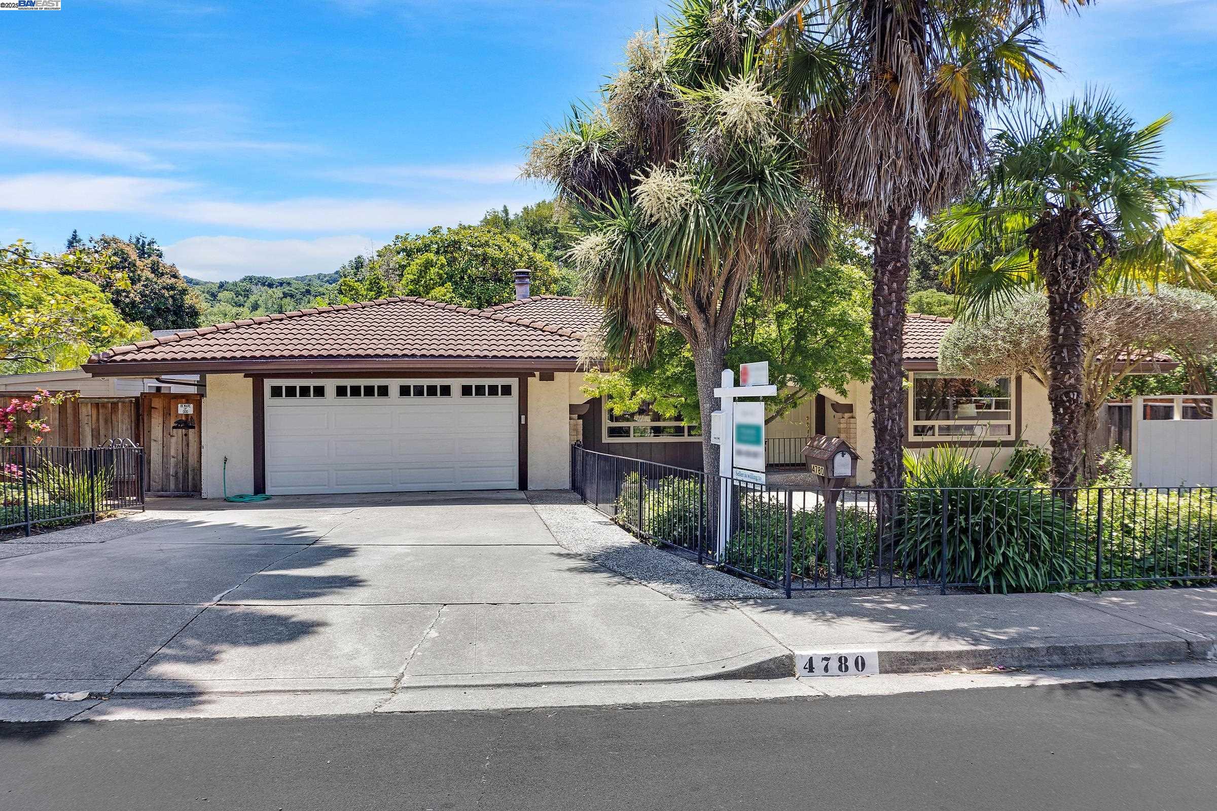 a view of a house with a small yard and palm trees