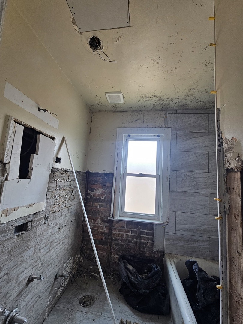 9439 South Racine Avenue Chicago, IL 60620 - Photo 6 of 11 a bathroom with a sink a toilet a window and vanity