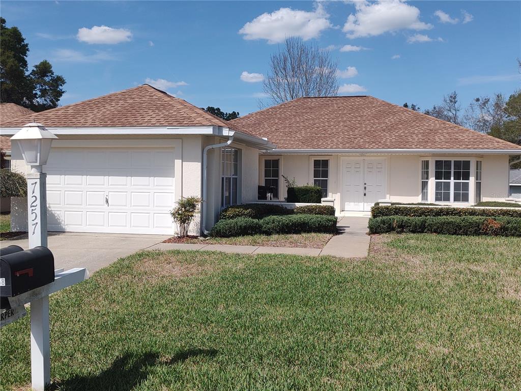 7257 Southwest 115th Place Ocala, FL 34476 - Photo 1 of 18 a front view of a house with garden