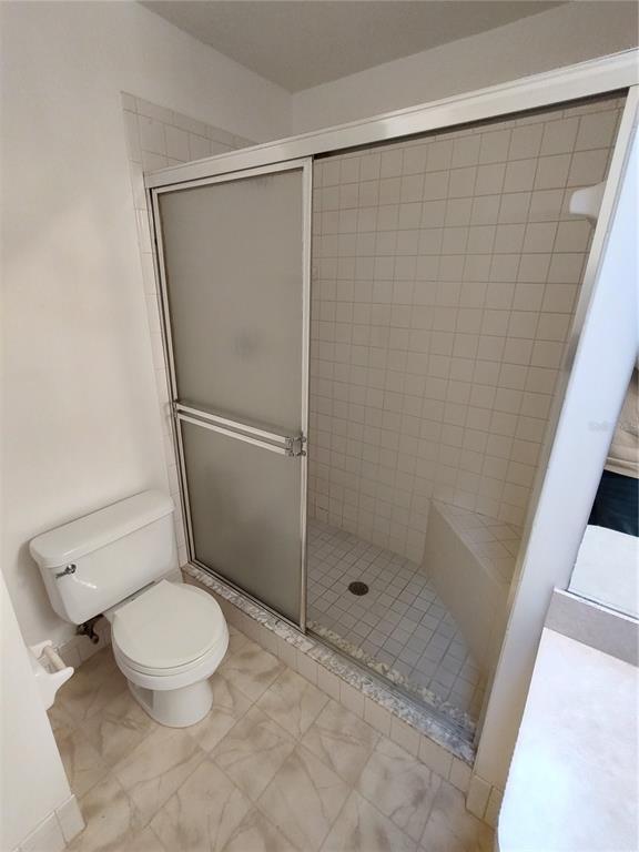 7257 Southwest 115th Place Ocala, FL 34476 - Photo 14 of 18 a white toilet sitting next to a shower
