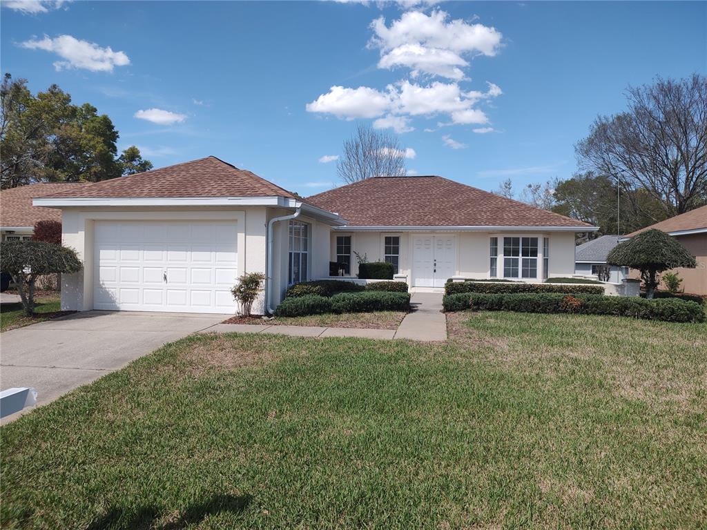 7257 Southwest 115th Place Ocala, FL 34476 - Photo 3 of 18 a front view of a house with a yard and garage
