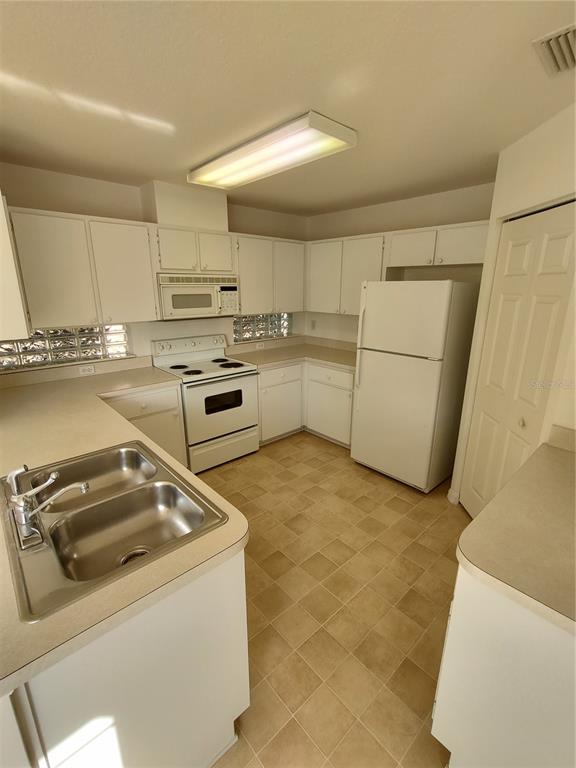 7257 Southwest 115th Place Ocala, FL 34476 - Photo 8 of 18 a kitchen with a sink appliances and cabinets