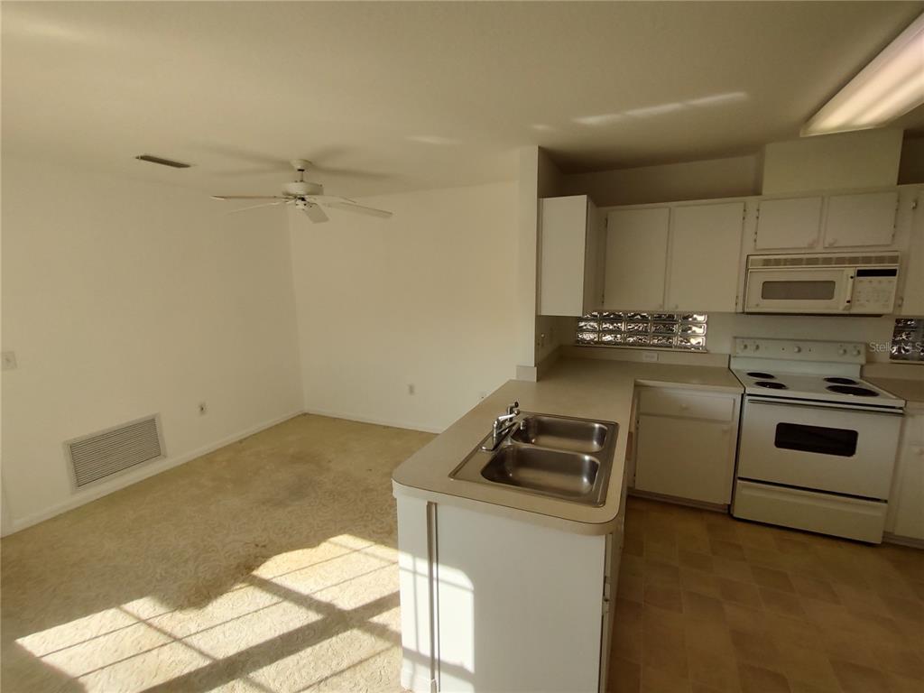 7257 Southwest 115th Place Ocala, FL 34476 - Photo 9 of 18 a kitchen that has a sink stove and cabinets