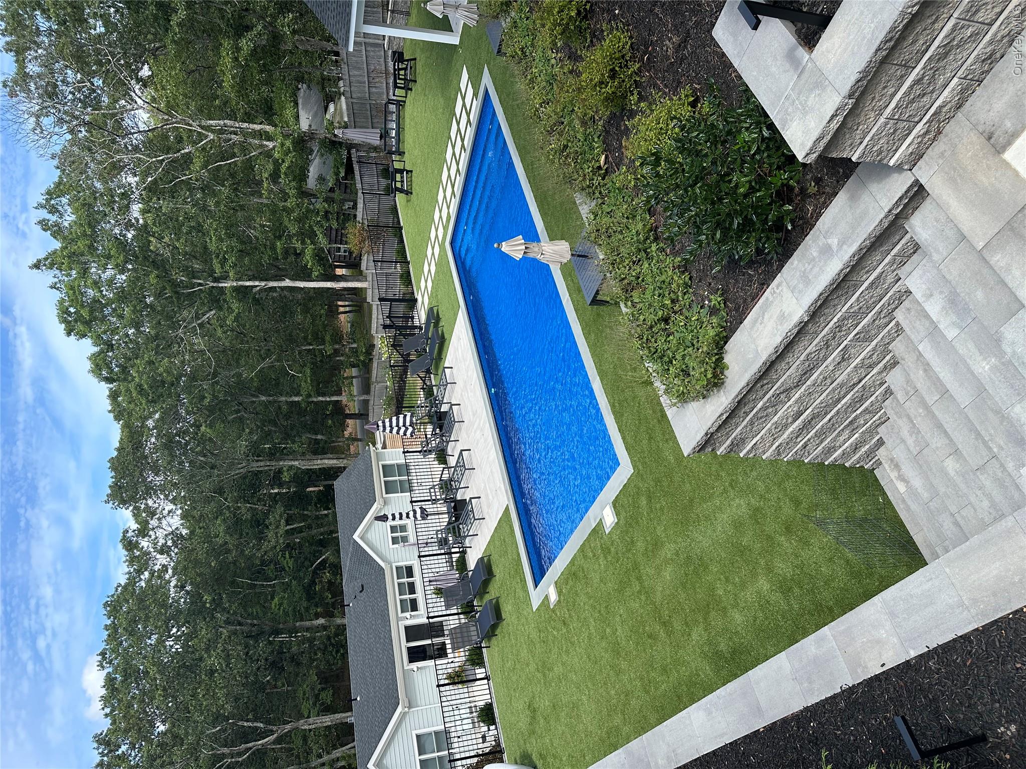 6 West Landing Road Hampton Bays, NY 11946 - Photo 13 of 44 a view of a swimming pool with a yard and sitting area