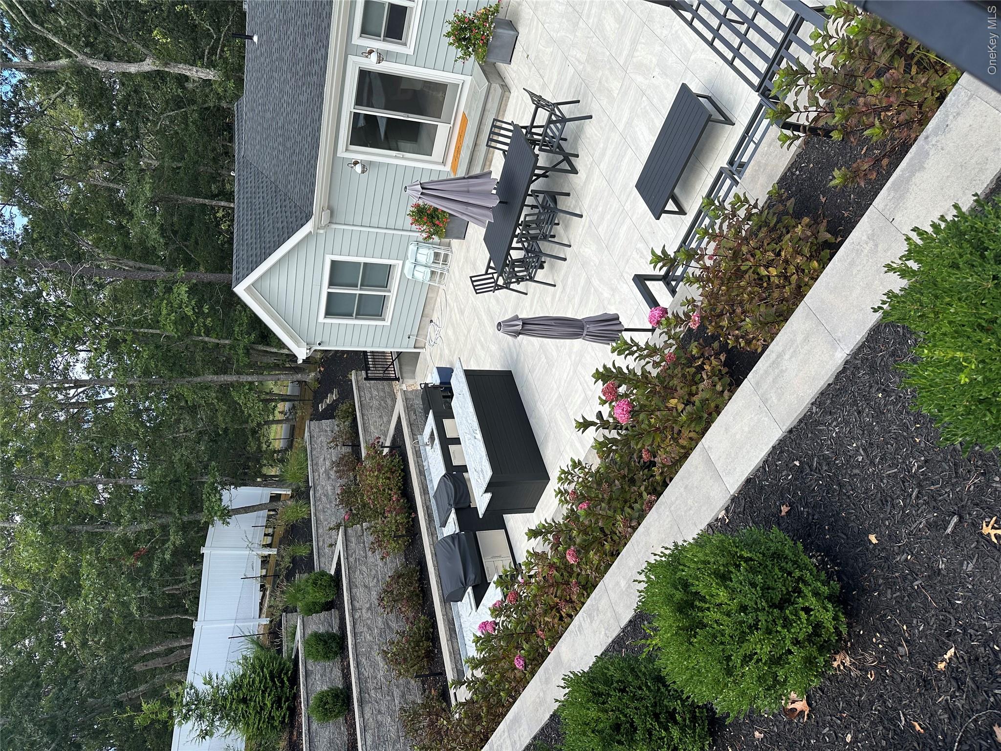 6 West Landing Road Hampton Bays, NY 11946 - Photo 8 of 44 a front view of house with yard and trees in the background