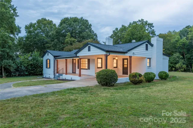 a view of a house with a yard and potted plants