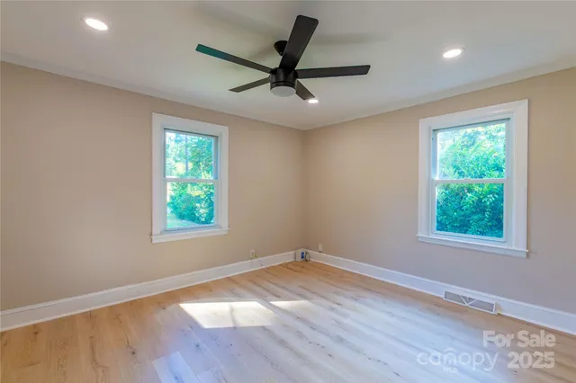 a view of a room with wooden floor and a ceiling fan