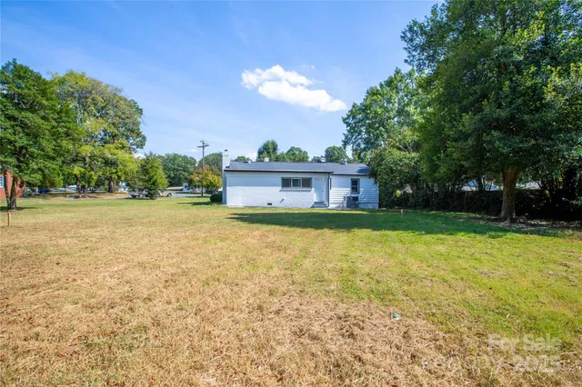 a view of an empty room with wooden floor and a fireplace