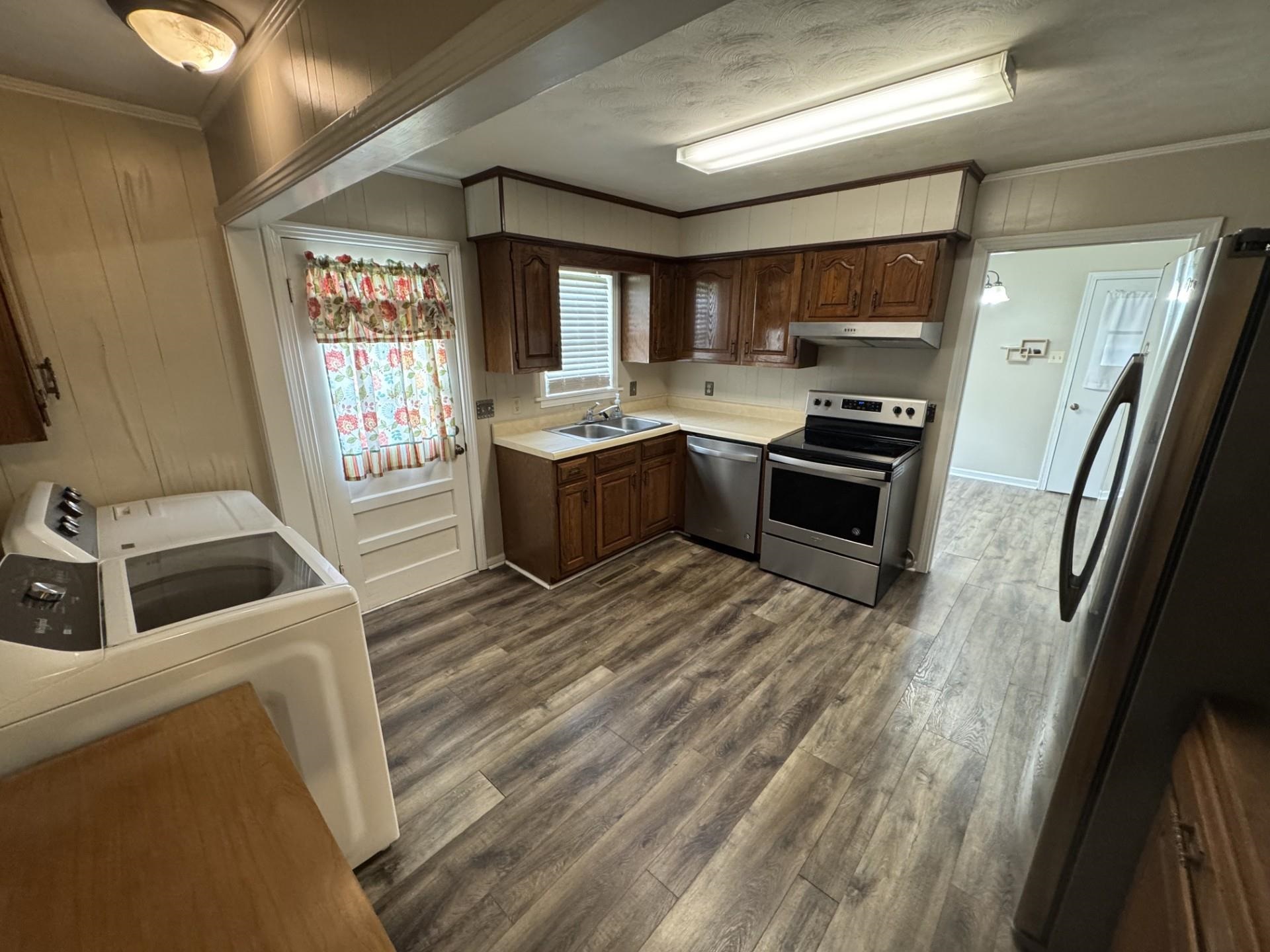 2631 Highway 51 Ripley, TN 38063 - Photo 9 of 17 Kitchen featuring stainless steel appliances, ornamental molding, exhaust hood, dark wood-style flooring, and light countertops