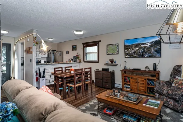 a living room with furniture a flat screen tv and a window