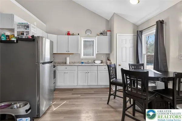 a kitchen with stainless steel appliances kitchen island granite countertop a table and chairs in it