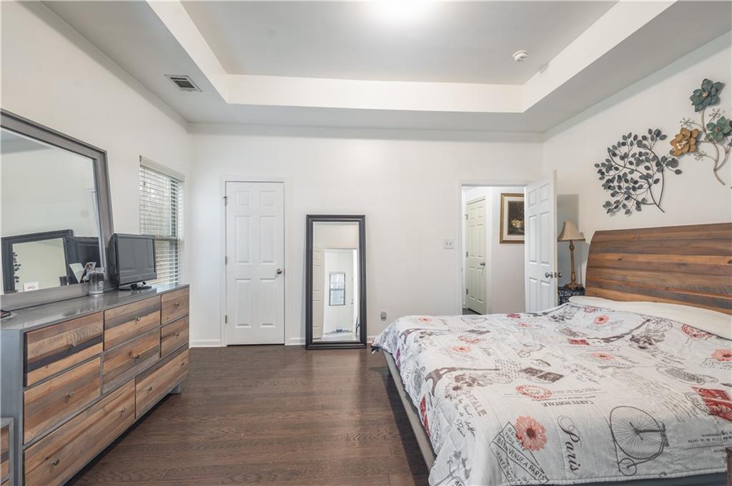 21 Sunny Point Newnan, GA 30263 - Photo 22 of 33 a bedroom with a large bed and a flat tv screen on dresser