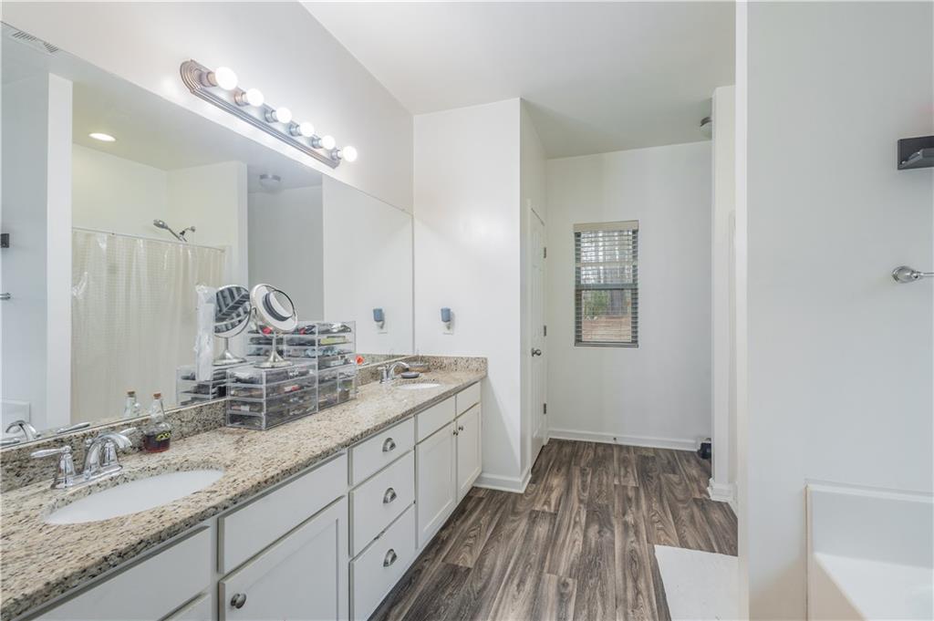 21 Sunny Point Newnan, GA 30263 - Photo 24 of 33 a spacious bathroom with a granite countertop double vanity sink a mirror and shower