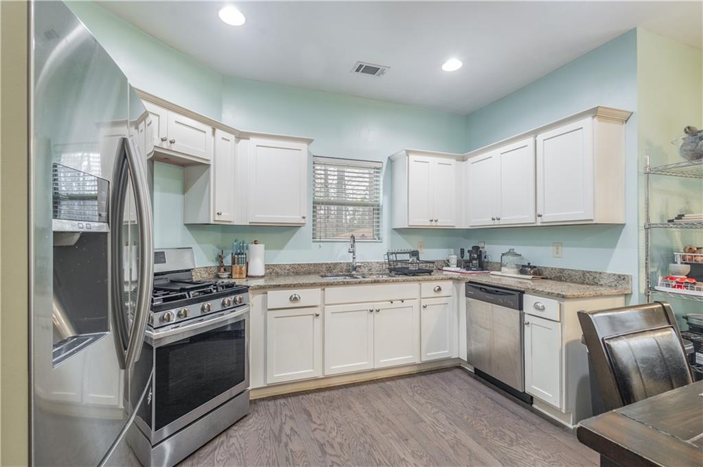 21 Sunny Point Newnan, GA 30263 - Photo 8 of 33 a kitchen with granite countertop a sink stainless steel appliances and cabinets