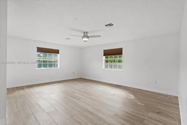 a view of a room with wooden floor and white walls