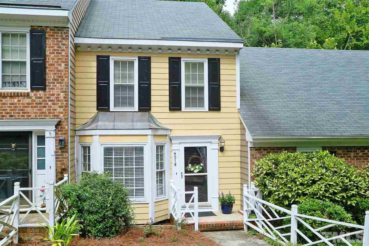 4518 Hamptonshire Drive Raleigh, NC 27613 - Photo 1 of 24 front view of a brick house with a large window and potted plants