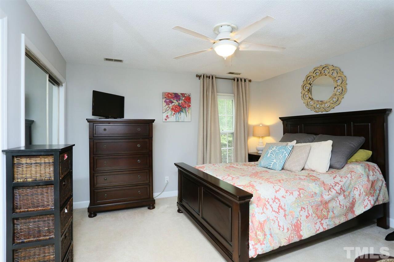 4518 Hamptonshire Drive Raleigh, NC 27613 - Photo 14 of 24 a bedroom with a bed and a chandelier