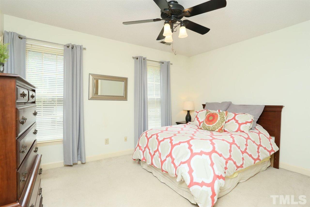 4518 Hamptonshire Drive Raleigh, NC 27613 - Photo 17 of 24 a bedroom with a large bed and a chandelier