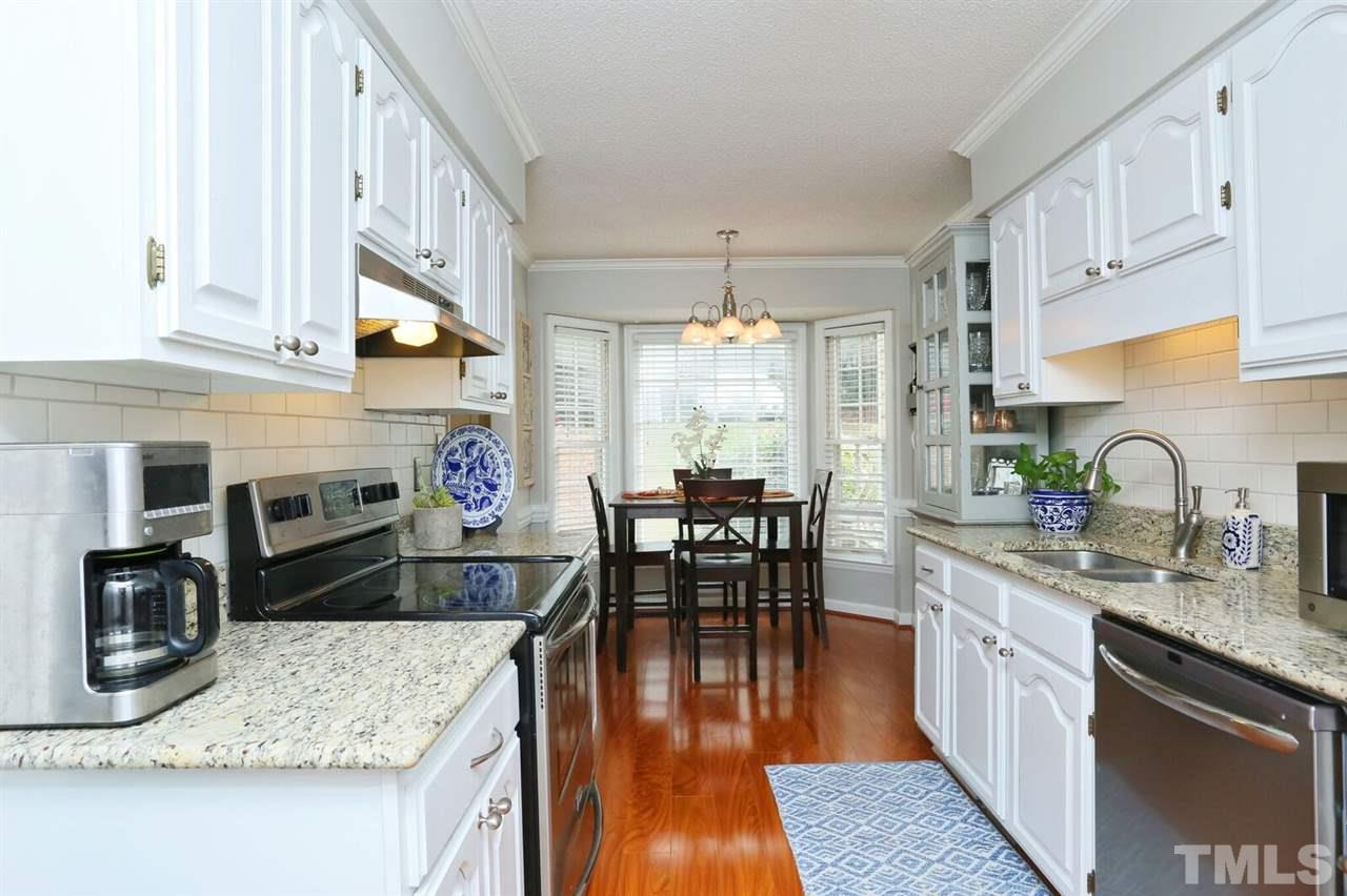 4518 Hamptonshire Drive Raleigh, NC 27613 - Photo 3 of 24 a kitchen with granite countertop kitchen island wooden floor center island and stainless steel appliances