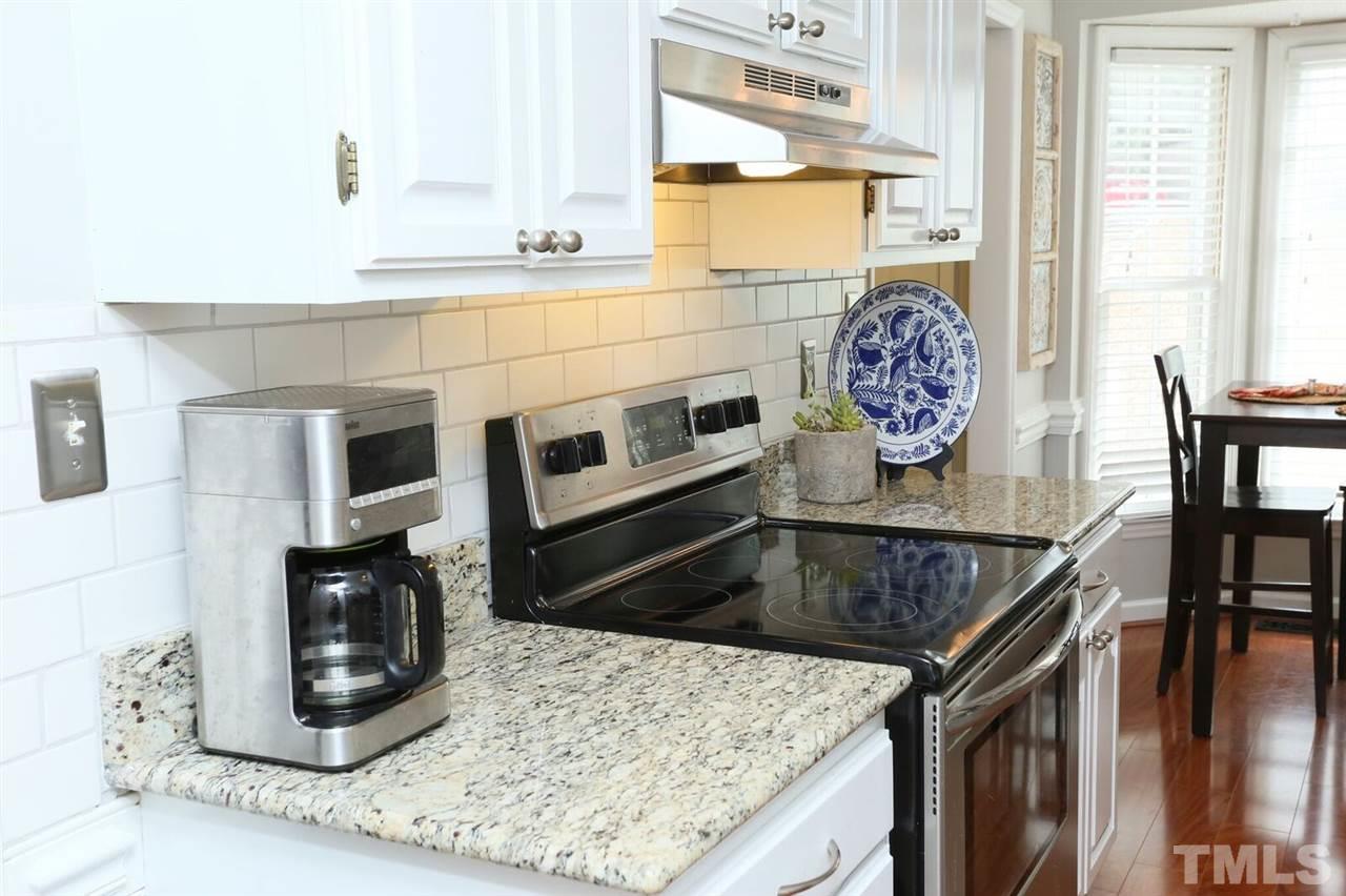 4518 Hamptonshire Drive Raleigh, NC 27613 - Photo 5 of 24 a kitchen with stainless steel appliances kitchen island granite countertop a stove a microwave a sink and cabinets