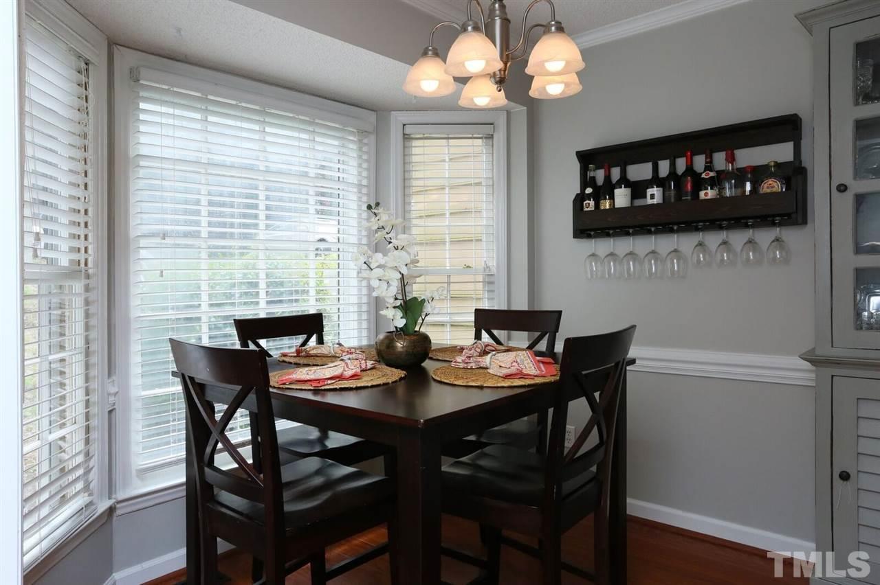 4518 Hamptonshire Drive Raleigh, NC 27613 - Photo 6 of 24 a view of a dining room with furniture a chandelier and wooden floor