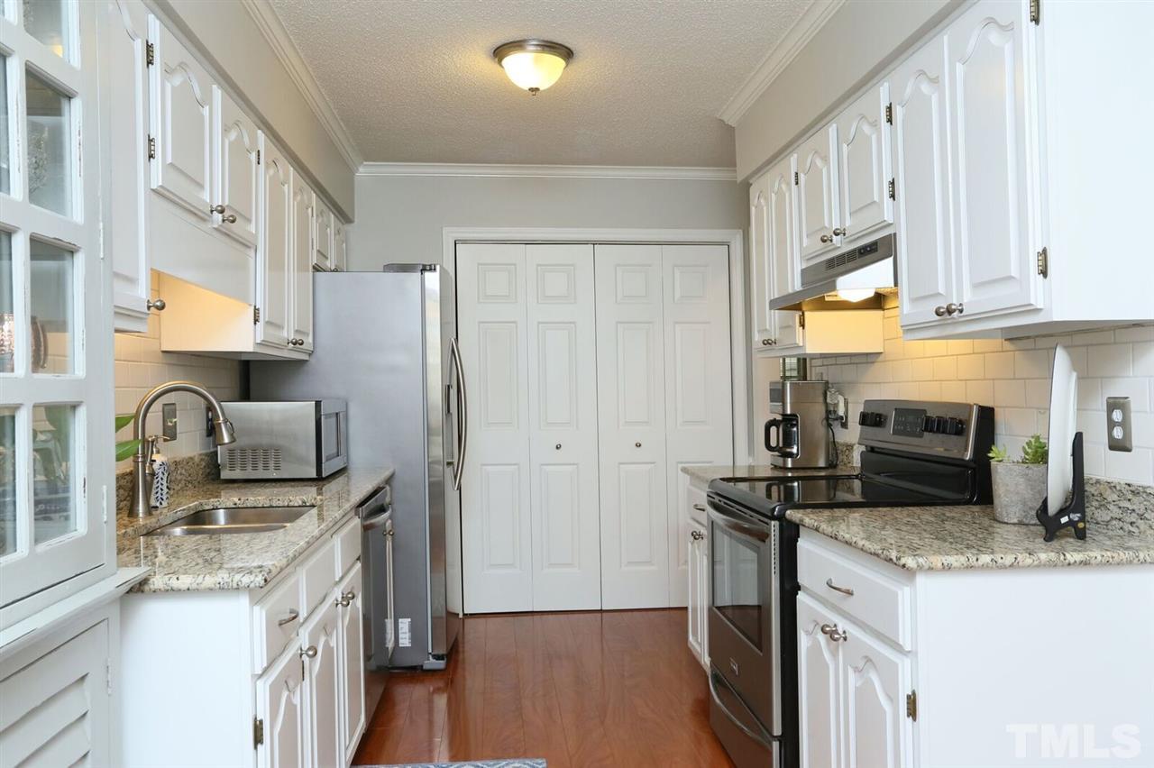 4518 Hamptonshire Drive Raleigh, NC 27613 - Photo 8 of 24 a kitchen with stainless steel appliances granite countertop a sink stove refrigerator and cabinets