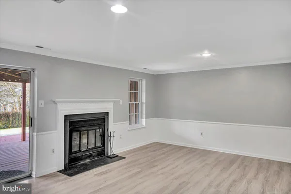 an empty room with wooden floor and fireplace