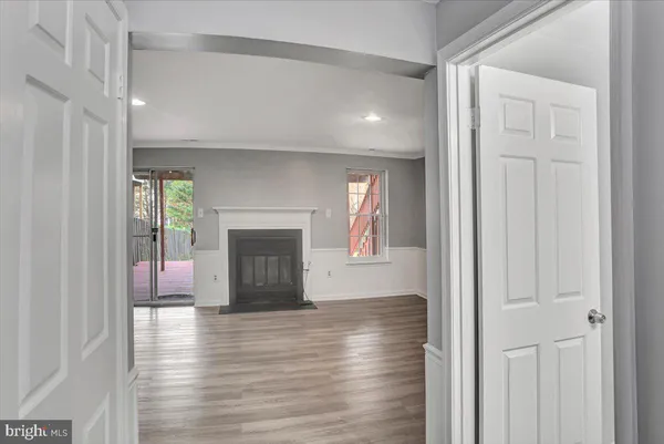 a view of a livingroom with wooden floor and a fireplace