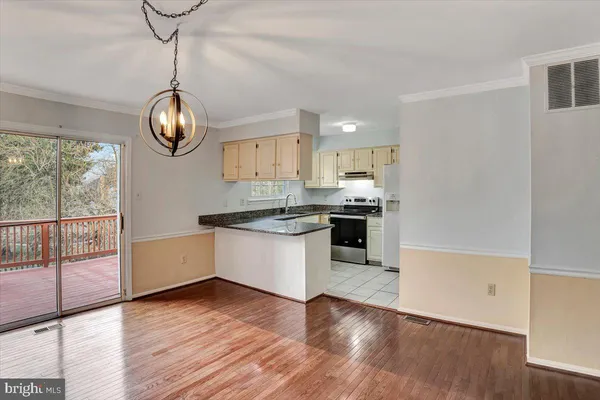 a kitchen with stainless steel appliances granite countertop a stove a sink and dishwasher with wooden floor